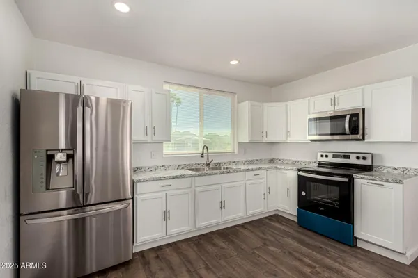 a kitchen with stainless steel appliances a refrigerator sink and microwave