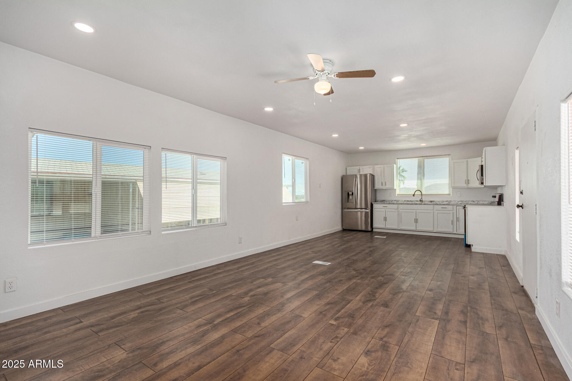 12814 North 19th Place, Unit 19 Phoenix, AZ 85022 - Photo 10 of 29 a view of an empty room with wooden floor and a window