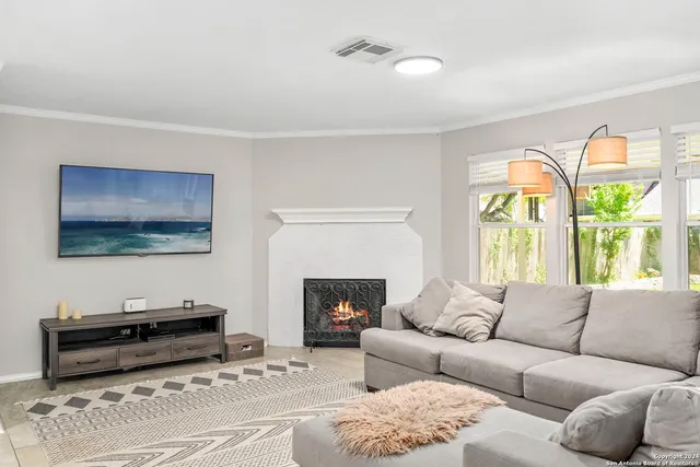 a living room with furniture a fireplace and a flat screen tv