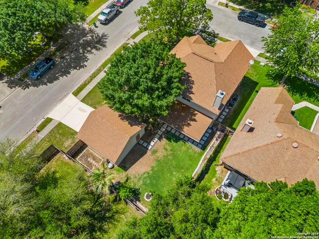 an aerial view of residential houses with outdoor space and trees