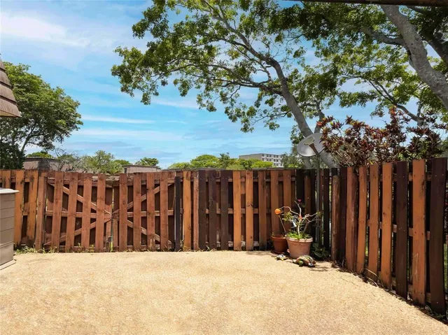 a view of wooden fence under a large tree