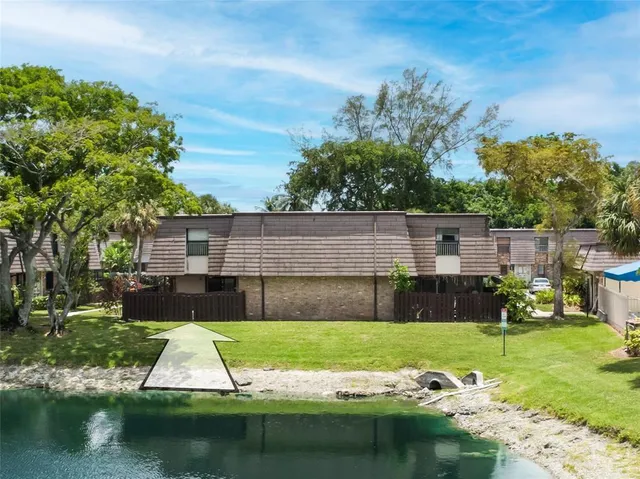 a view of house with swimming pool and a yard
