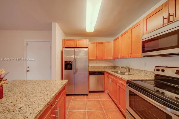 a kitchen with granite countertop a stove top oven microwave and cabinets