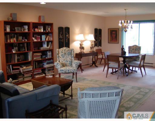 735 B Prospect Road Monroe Township, NJ 08831 - Photo 3 of 8 a living room with furniture a bookshelf and a chandelier