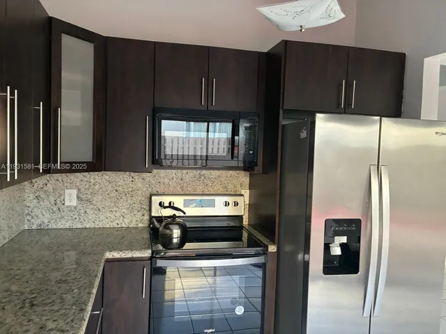 a kitchen with a refrigerator sink and cabinets