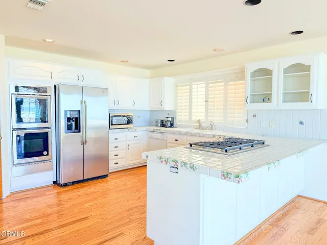 a kitchen with granite countertop a sink stove and refrigerator