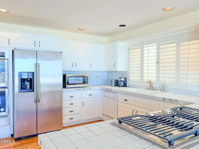 a kitchen with stainless steel appliances a refrigerator sink and cabinets
