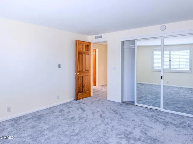 an empty room with windows and closet