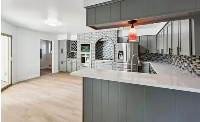 a kitchen with stainless steel appliances a sink and a refrigerator