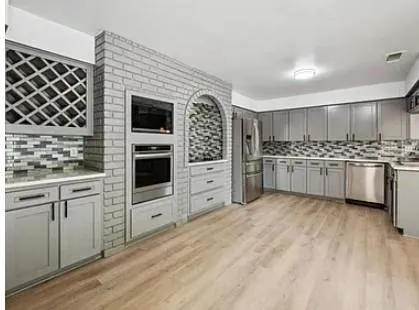 a kitchen with white cabinets and appliances