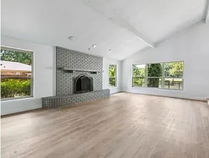 an empty room with fireplace and windows
