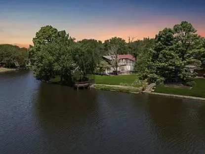 an aerial view of a house with a yard and lake view