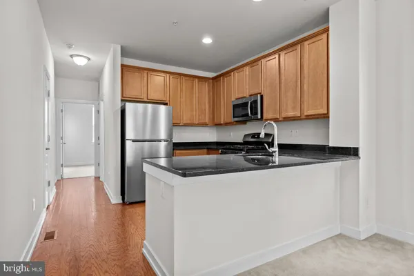 a kitchen with granite countertop a stove a sink and a microwave