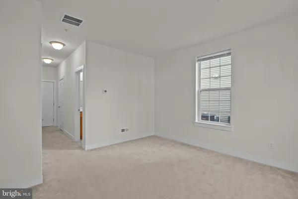 an empty room with windows and closet