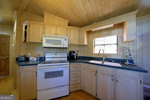 a kitchen with cabinets appliances a sink and a window