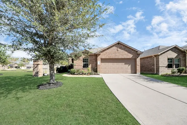 a front view of a house with a yard and tree s
