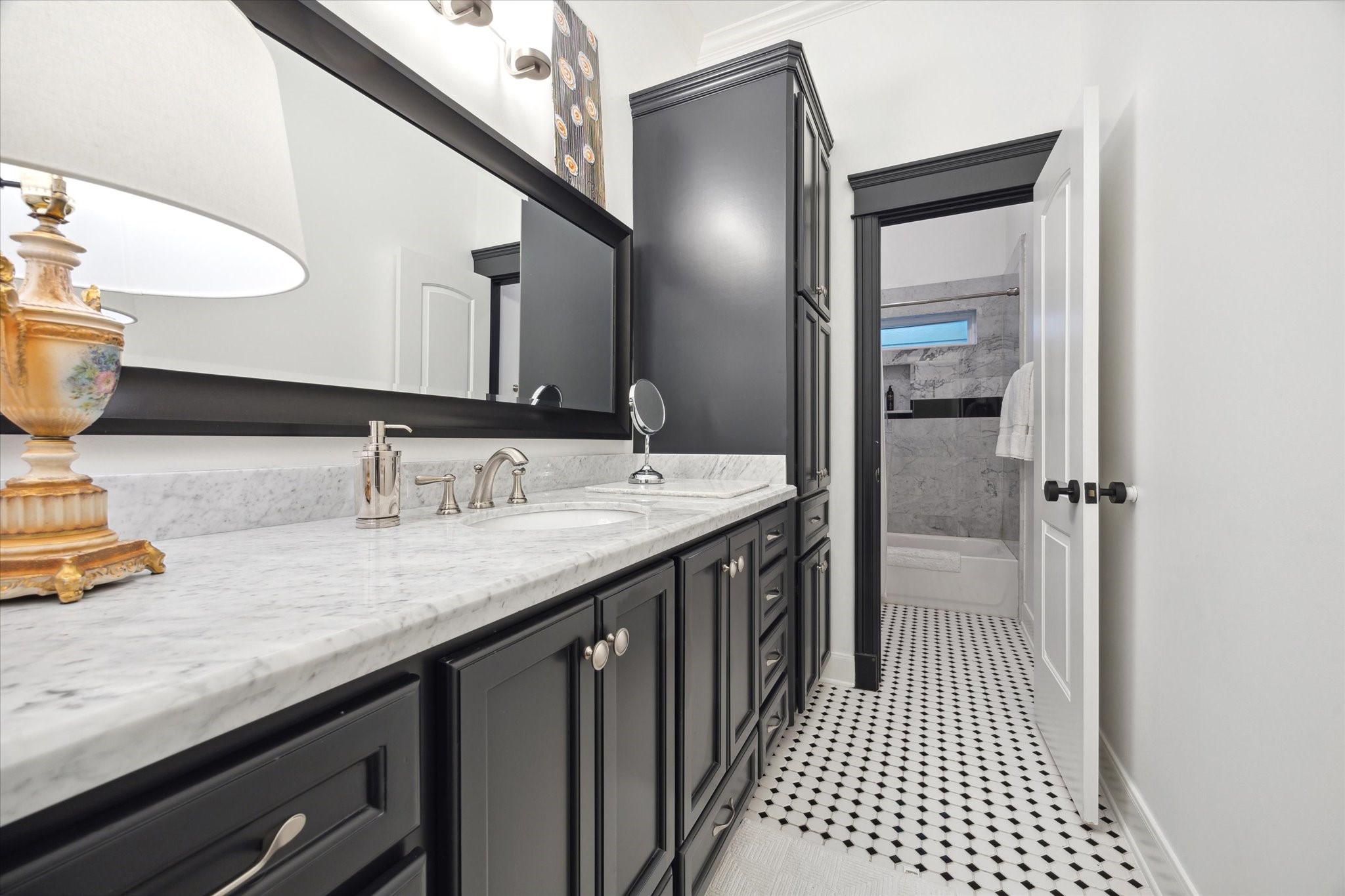 606 Rutland Street Houston, TX 77007 - Photo 37 of 48 This bathroom features elegant black cabinetry with a marble countertop and dual sinks.