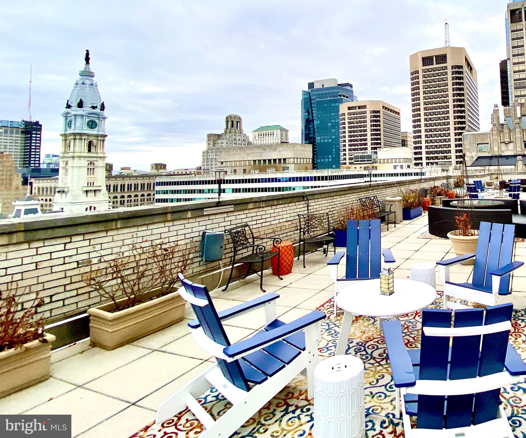 a view of roof deck with outdoor seating and city view