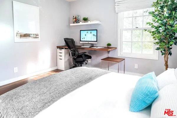 a bedroom with a bed and a large window