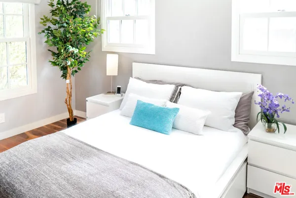 a bedroom with a bed and a potted plant