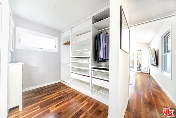 a view of a bedroom with wooden floor and windows