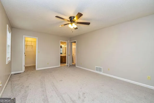 an empty room with closet and a chandelier fan