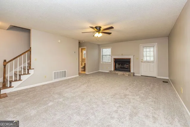 an empty room with fireplace and fan