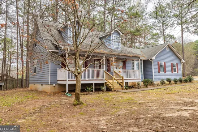 a view of a house with a yard and large trees