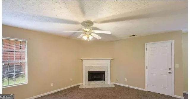 an empty room with windows and fan