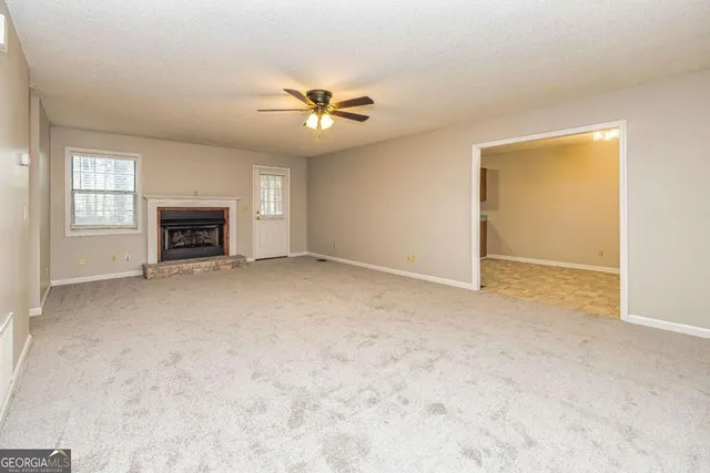 an empty room with fireplace and windows