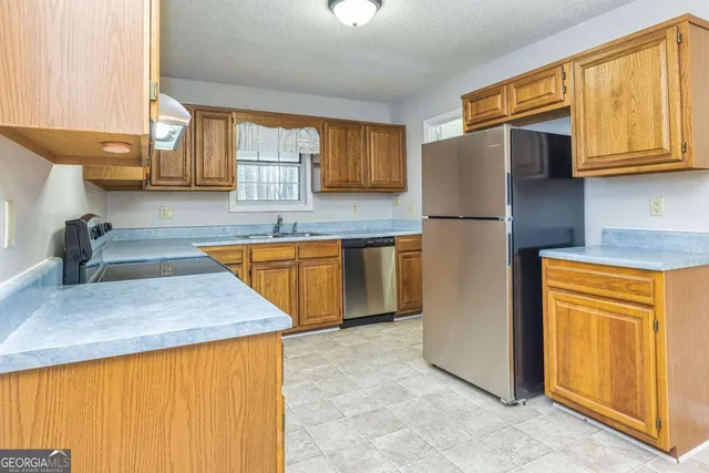a kitchen with stainless steel appliances granite countertop a sink refrigerator and microwave
