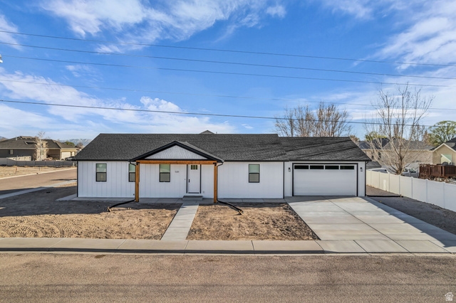 520 East 450th Street North Delta, UT 84624 - Photo 5 of 48 View of front of house featuring driveway, covered porch, a garage, and roof with shingles