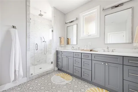 a bathroom with a granite countertop sink mirror and shower