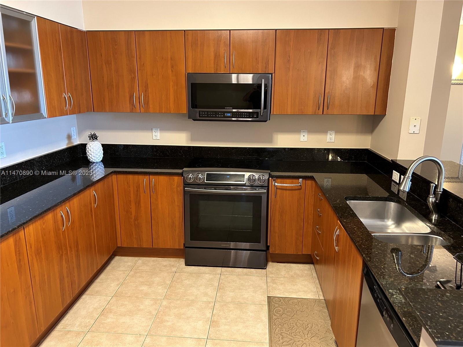 233 South Federal Highway, Unit 609 Boca Raton, FL 33432 - Photo 7 of 24 a kitchen with granite countertop a stove top oven microwave and cabinets
