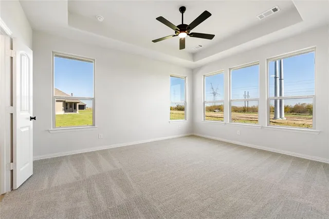 a view of an empty room with a window and kitchen