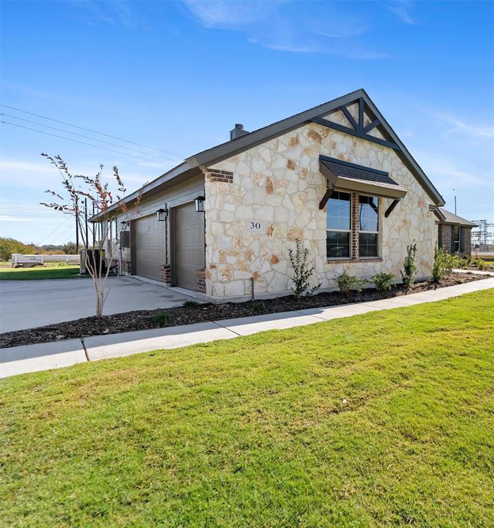 30 Roosevelt Ln Valley View Valley View, TX 76272 - Photo 5 of 35 View of front of house featuring stone siding, concrete driveway, a garage, and a front yard
