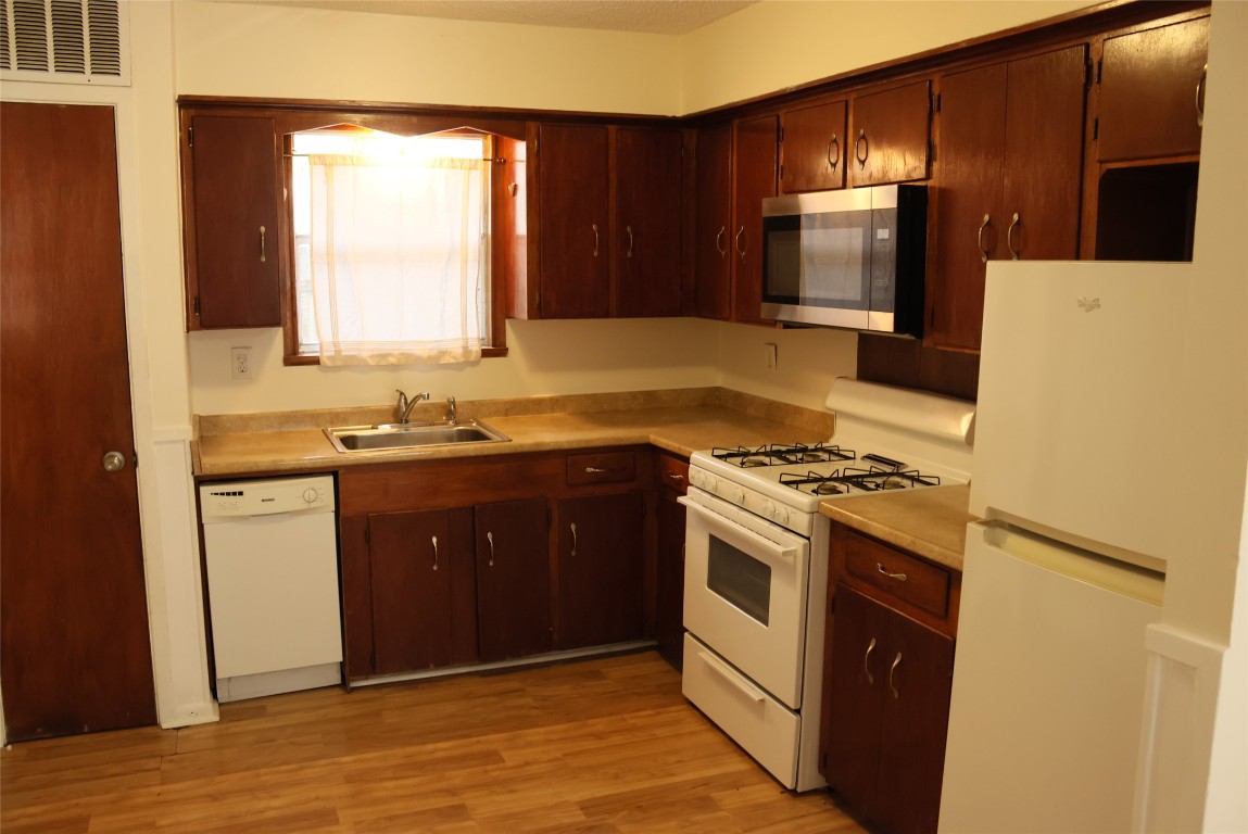 2713 St Edwards Circle, Unit A Austin, TX 78704 - Photo 5 of 11 Kitchen featuring white appliances, light countertops, and light wood-style flooring