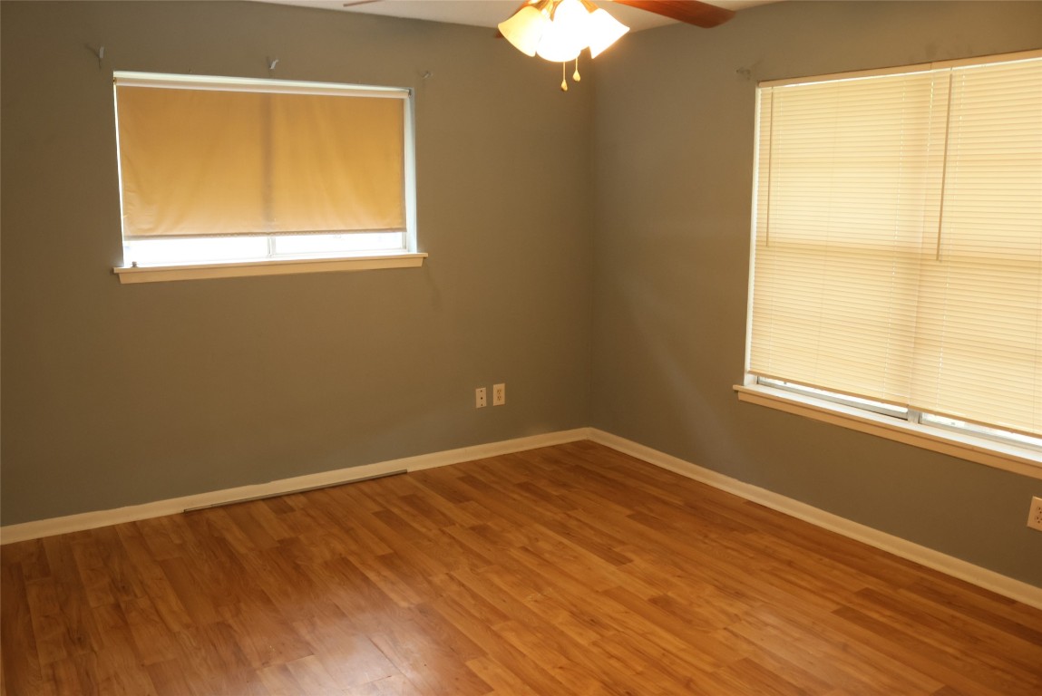 2713 St Edwards Circle, Unit A Austin, TX 78704 - Photo 6 of 11 Empty room featuring a ceiling fan and wood laminate floors