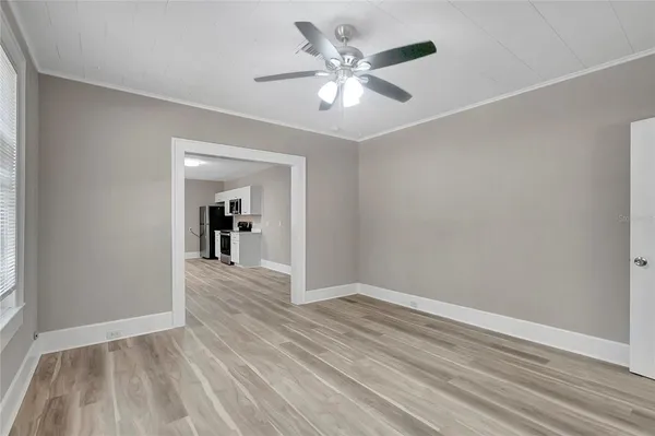 a view of a hallway with wooden floor and a chandelier fan