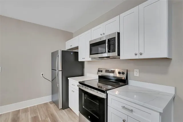a kitchen with a refrigerator stove and microwave