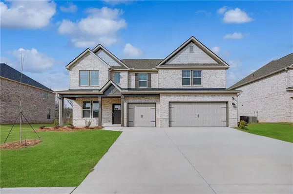 a front view of a house with a yard and garage