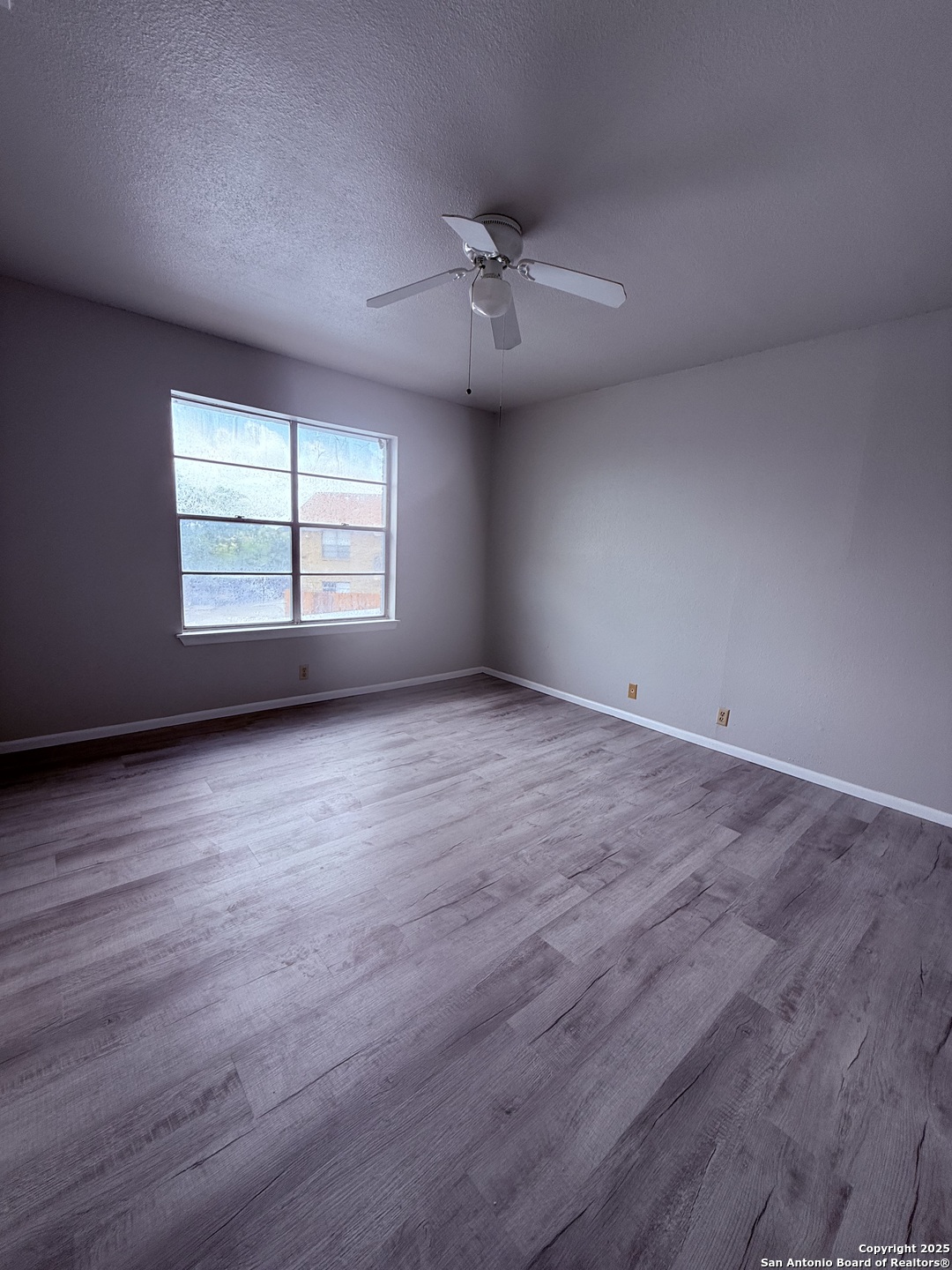 923 Vance Jackson Road, Unit 804 San Antonio, TX 78201 - Photo 7 of 10 an empty room with wooden floor and windows