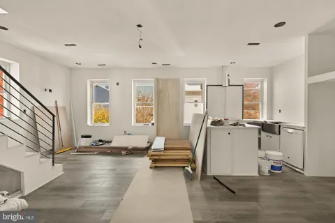 a dining room with wooden floor a chandelier a wooden table and chairs