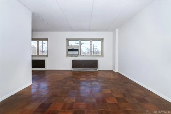 a view of empty room with a fireplace and wooden floor