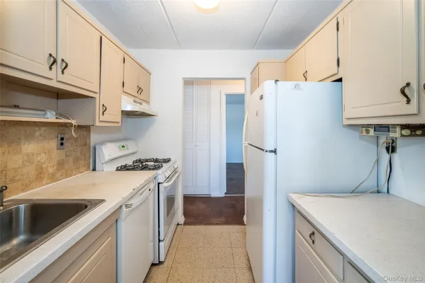 a kitchen with a sink a refrigerator and a stove