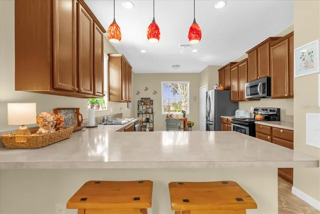 a kitchen with stainless steel appliances granite countertop a sink dishwasher and a microwave with wooden cabinets