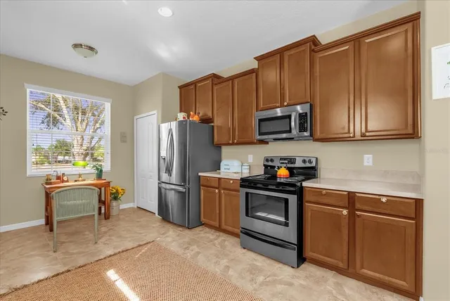 a kitchen with stainless steel appliances granite countertop a refrigerator stove microwave and sink