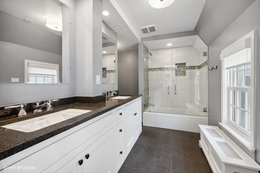 626 Warwick Road Kenilworth, IL 60043 - Photo 26 of 56 a spacious bathroom with a granite countertop sink a mirror a bathtub and shower