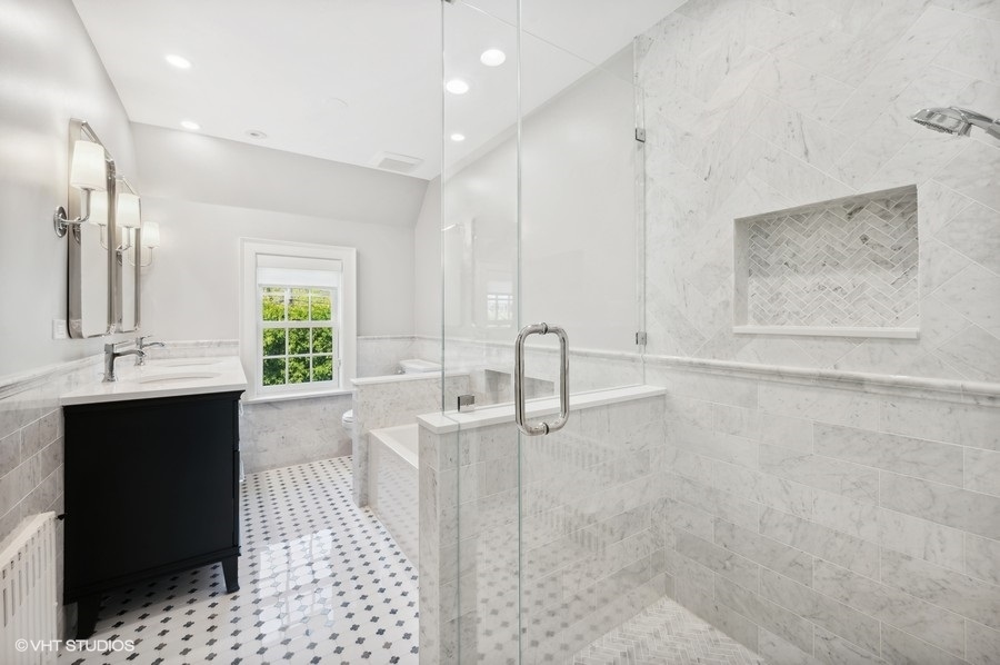 626 Warwick Road Kenilworth, IL 60043 - Photo 28 of 56 a bathroom with a double vanity sink a mirror and a bathtub