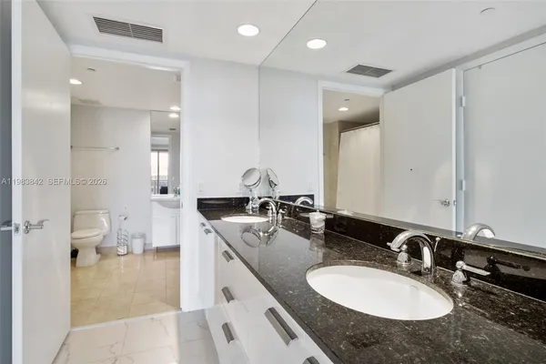 a bathroom with a granite countertop sink and a mirror